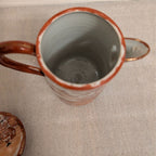 Hand-painted porcelain coffee pot, orange rim, empty interior visible