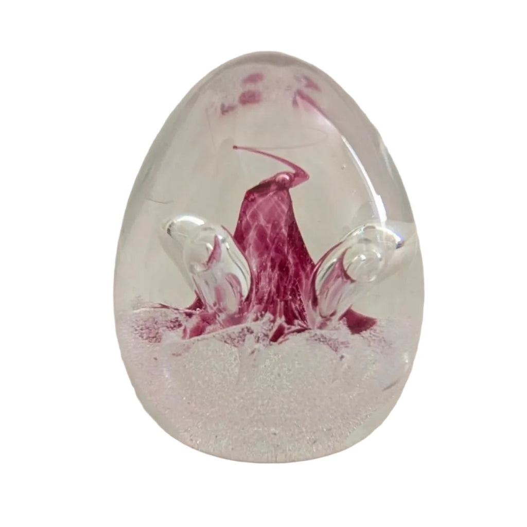 Glass paperweight with pink floral swirl and clear oval base