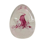Glass paperweight with pink floral swirl and clear oval base