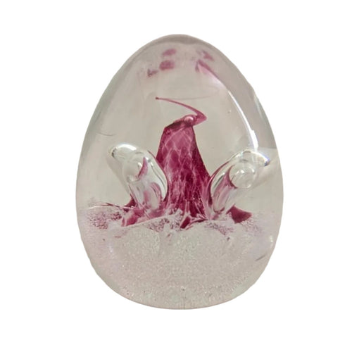 Glass paperweight with pink floral swirl and clear oval base