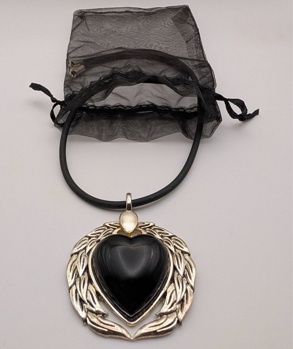 Black heart pendant necklace with silver winged setting and black cord