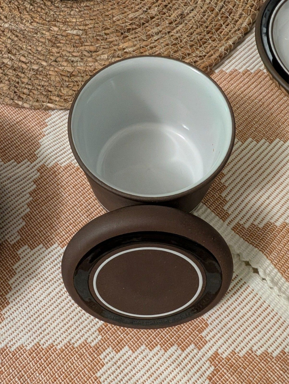 Stoneware teacup and saucer set in brown with light interior and dark ring