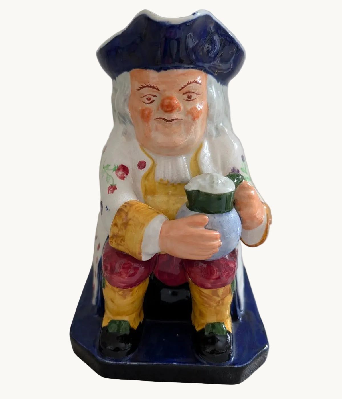 Spode Toby jug character pitcher with blue cap, holding a small bottle, hand-painted