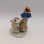 Pottery couple figurine, side view: blue tassel hat figure with seated partner