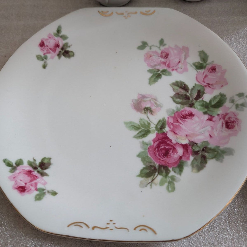Porcelain dinner plate with pink rose bouquets and green leaves, gold rim accents