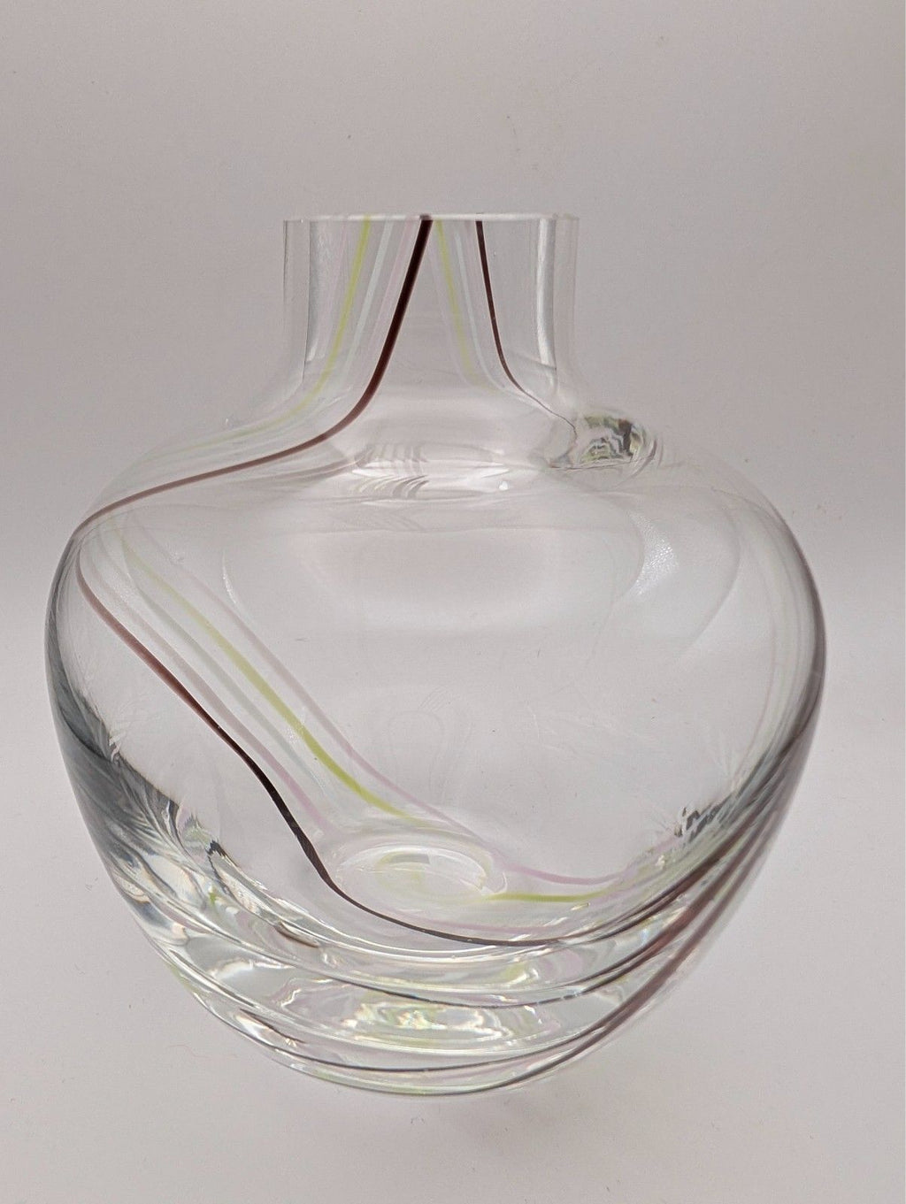 Clear glass bud vase with internal swirl, wide round body and narrow neck