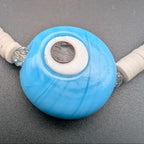 Blue evil-eye pendant with white center and dark inner disk on beaded choker