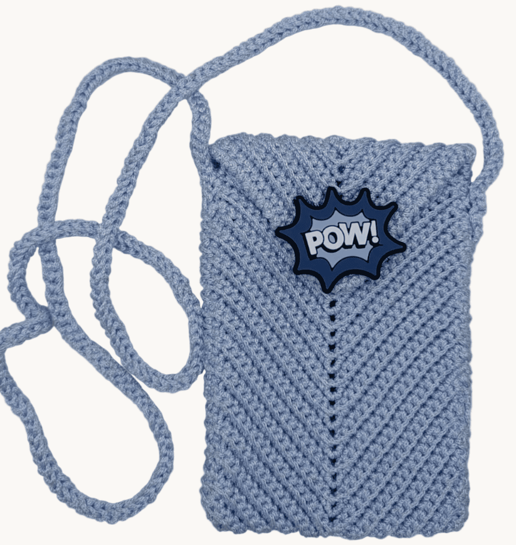 Light blue crochet crossbody phone bag with POW patch and carrying strap