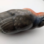 Close-up of hand-painted porcelain robin figurine, orange chest and gray wing details