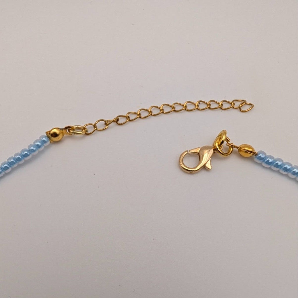 Gold clasp and chain on light blue beaded choker necklace
