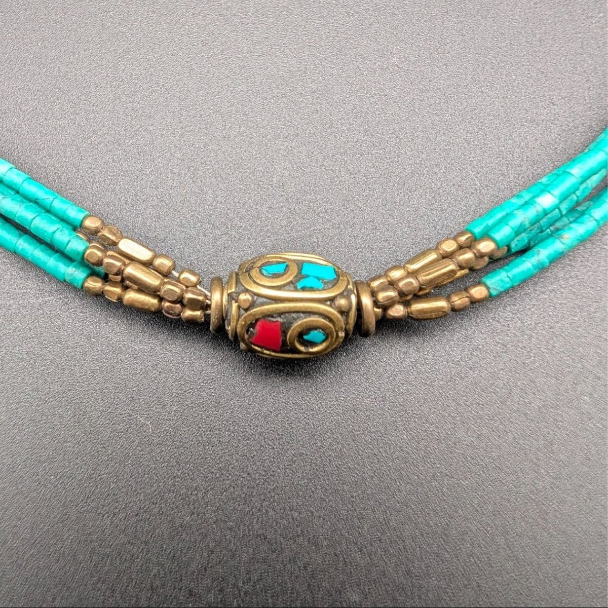 Turquoise multi-strand beaded choker with bronze medallion and turquoise accents