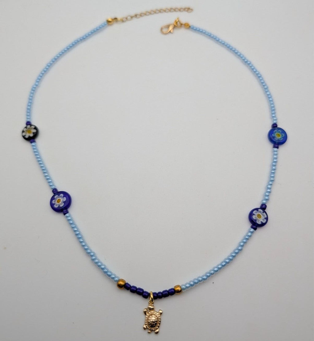 Light blue beaded choker with blue flower beads and gold turtle charm