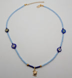 Light blue beaded choker with blue flower beads and gold turtle charm