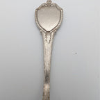 Souvenir collector spoon with engraved side and rounded decorative top end