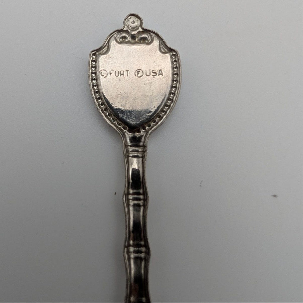 Souvenir metal spoon with engraved 'FORT USA' on back of oval crest