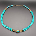 Turquoise multi-strand beaded choker with bronze spacer beads and central charm