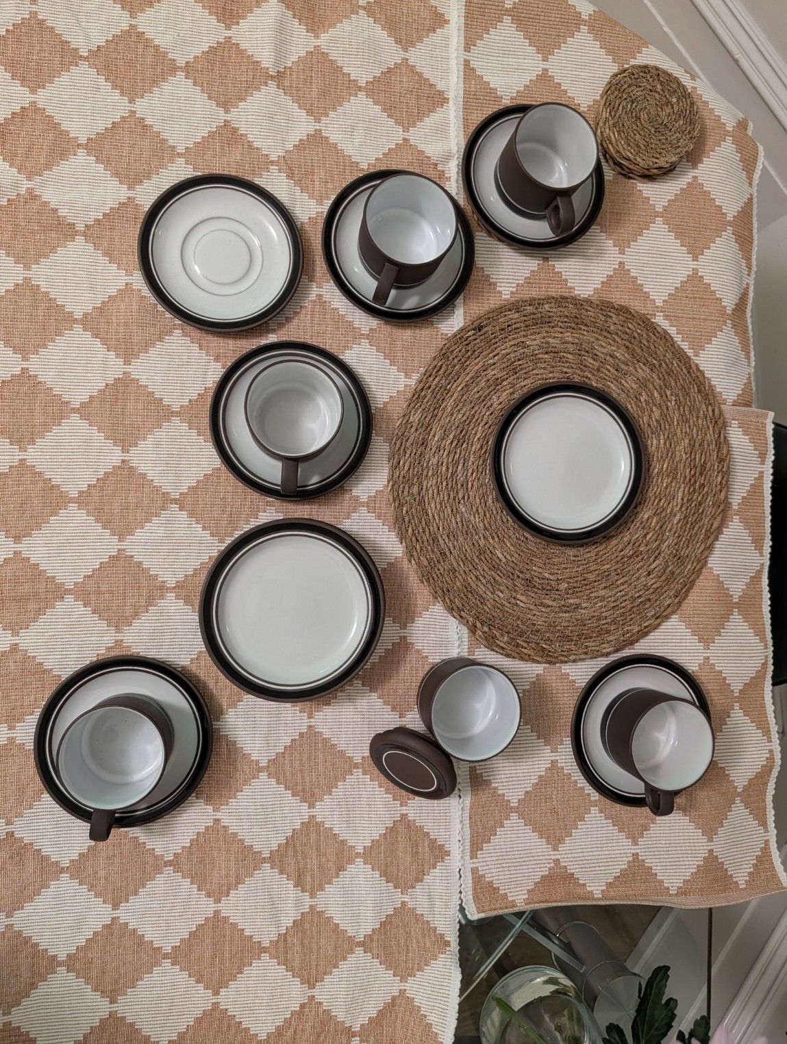 Assorted stoneware tea and coffee set pieces: cups, saucers, and contrast-rim plates