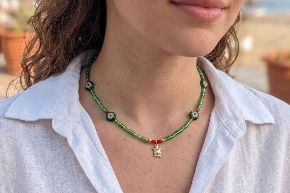 Green glass bead choker necklace with turtle charm pendant and red accents