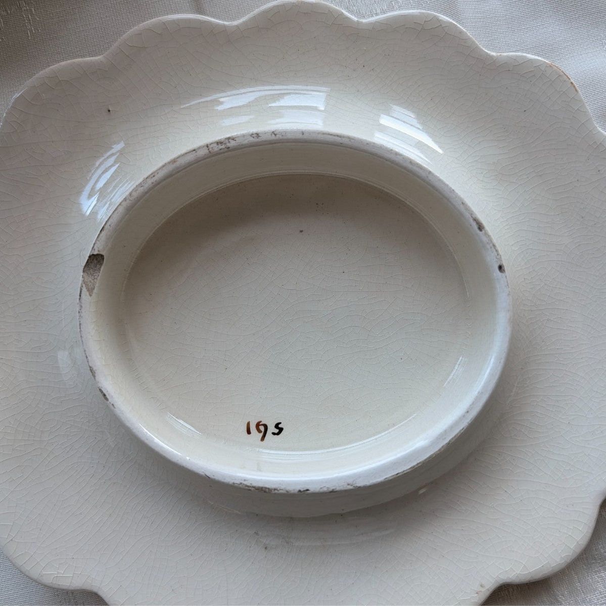 Cream porcelain base marked "195" inside, scalloped stand underside