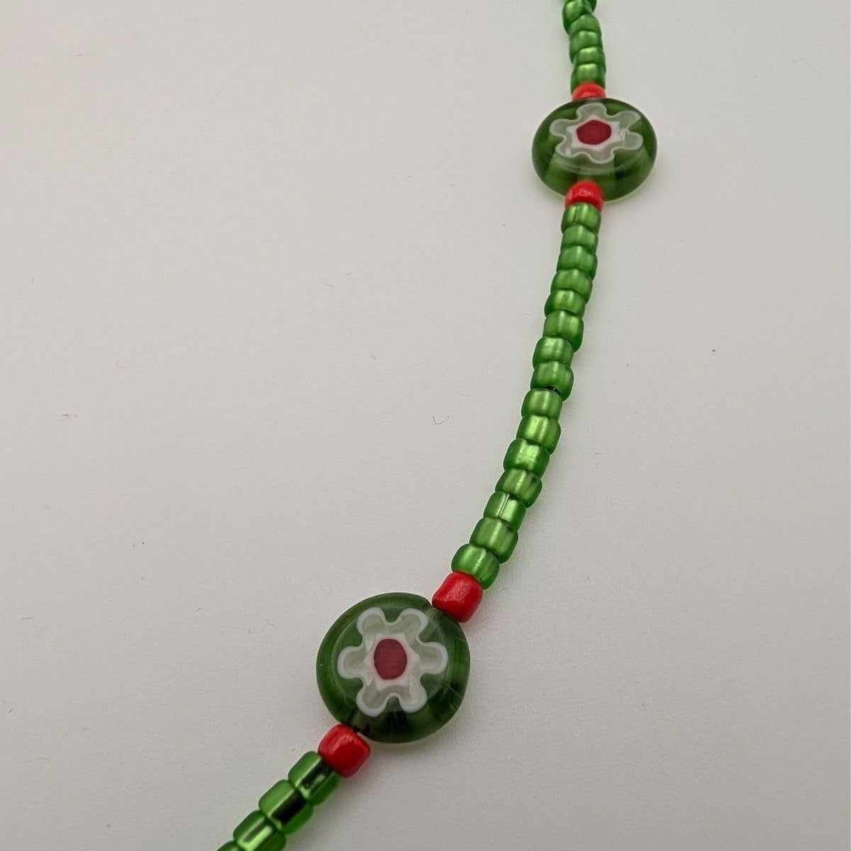Green glass bead choker with turtle-shaped millefiori bead and red spacer beads