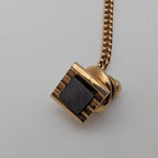 Gold-tone geometric tie tack pin with square black stone and chain back