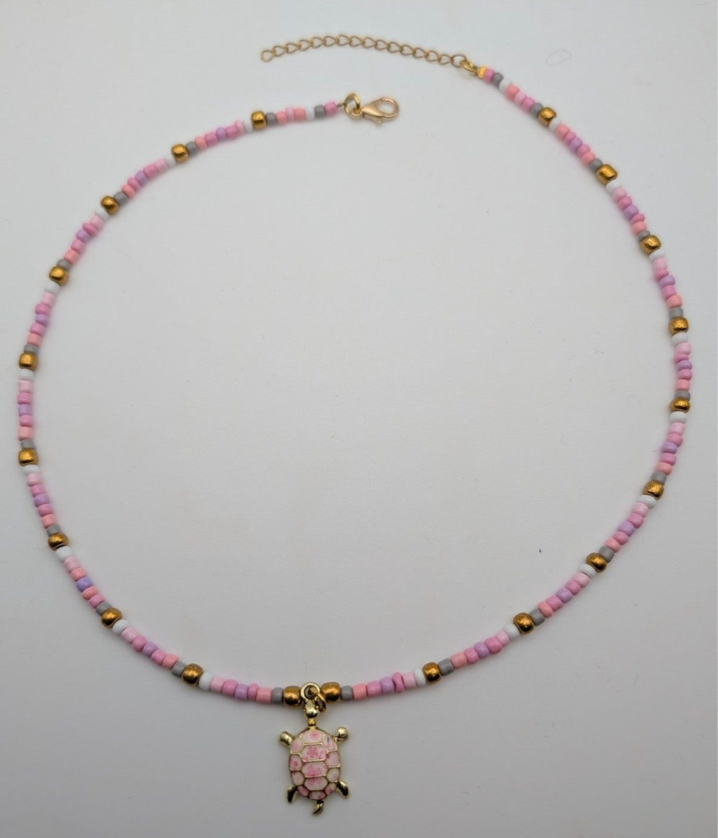 Pink beaded sea turtle choker necklace with small gold-tone turtle pendant and clasp