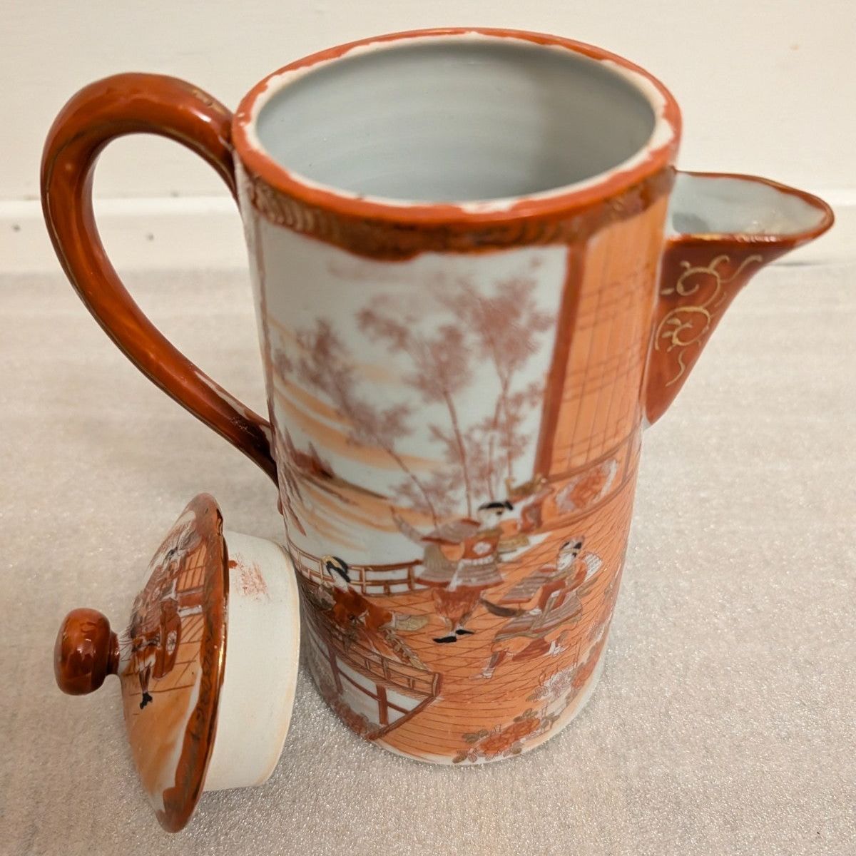 Hand-painted porcelain coffee pot with lid, orange-brown handle, scenic panel