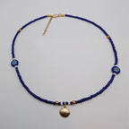 Blue glass beaded choker with seashell pendant and flower bead accents