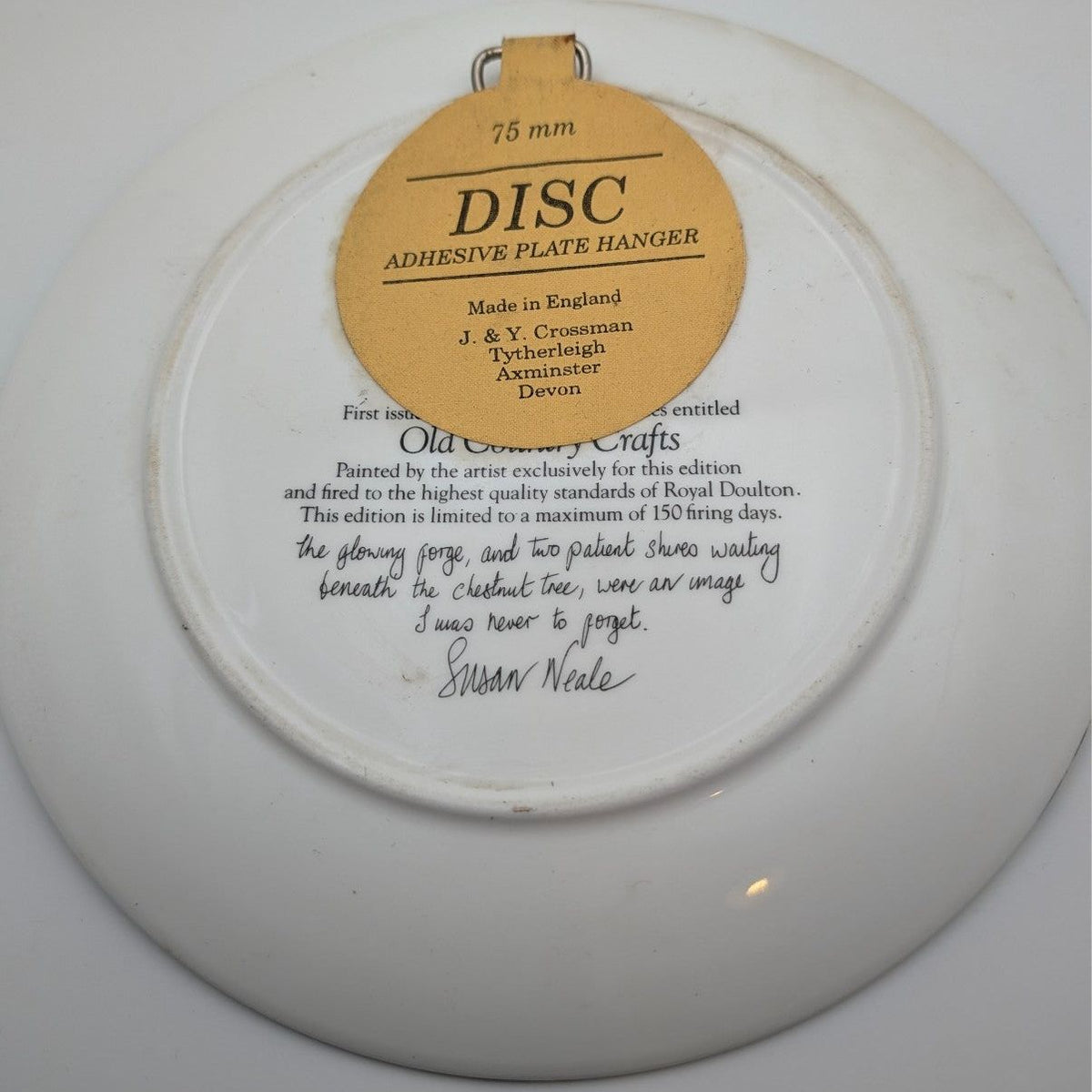 Collector plate back with hanging label and copyright text, round ceramic disc