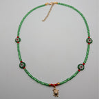 Green beaded choker necklace with turtle pendant, round millefiori bead accents