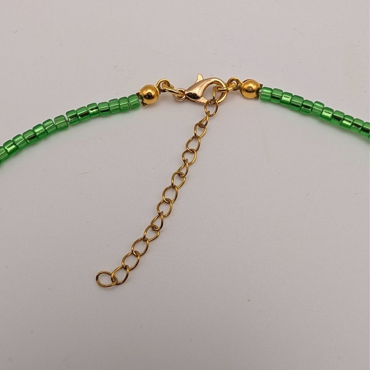 Green glass bead choker necklace with gold chain clasp and extender link
