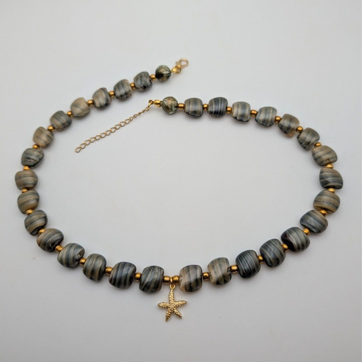 Grey stone bead necklace with gold starfish pendant and chain clasp