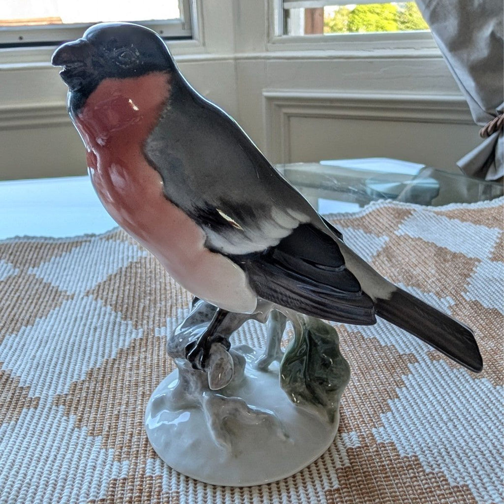 Porcelain bullfinch figurine in profile, dark body with pink breast on white base