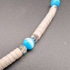 Beaded choker strand with cream heishi beads, blue beads, and silver spacer accents