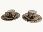 Porcelain tea cup and saucer with ornate multicolor band and floral motifs