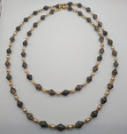 Long layered bead necklace with grey speckled stones and pearl-like beads