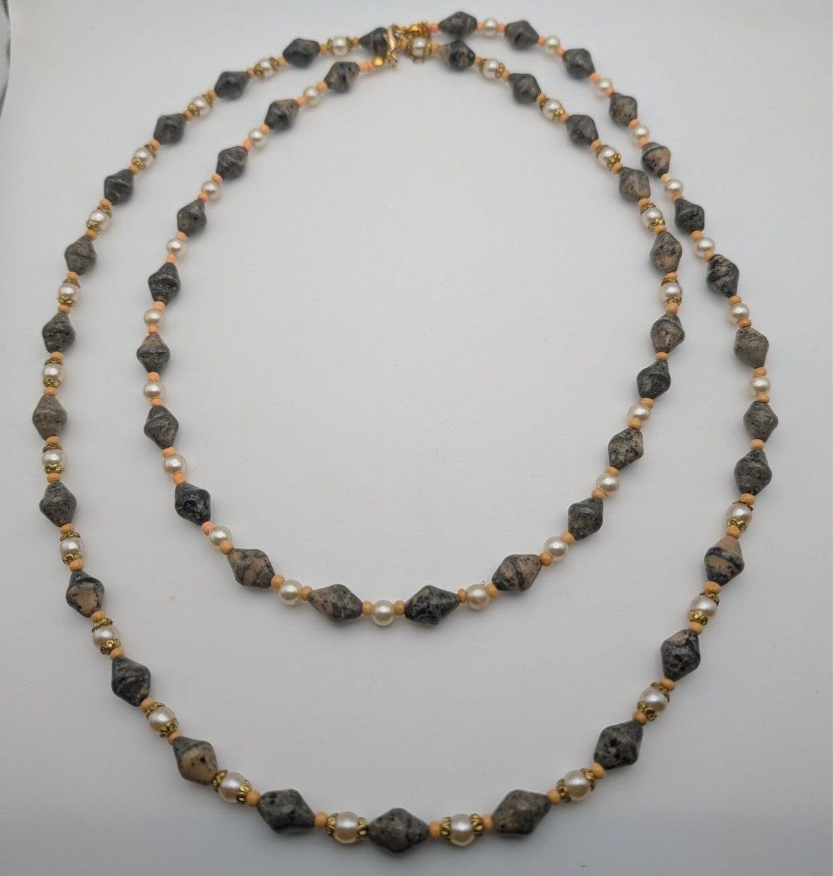 Long layered bead necklace with grey speckled stones and pearl-like beads