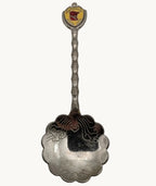 Souvenir metal spoon with round state fair emblem and ornate scalloped bowl