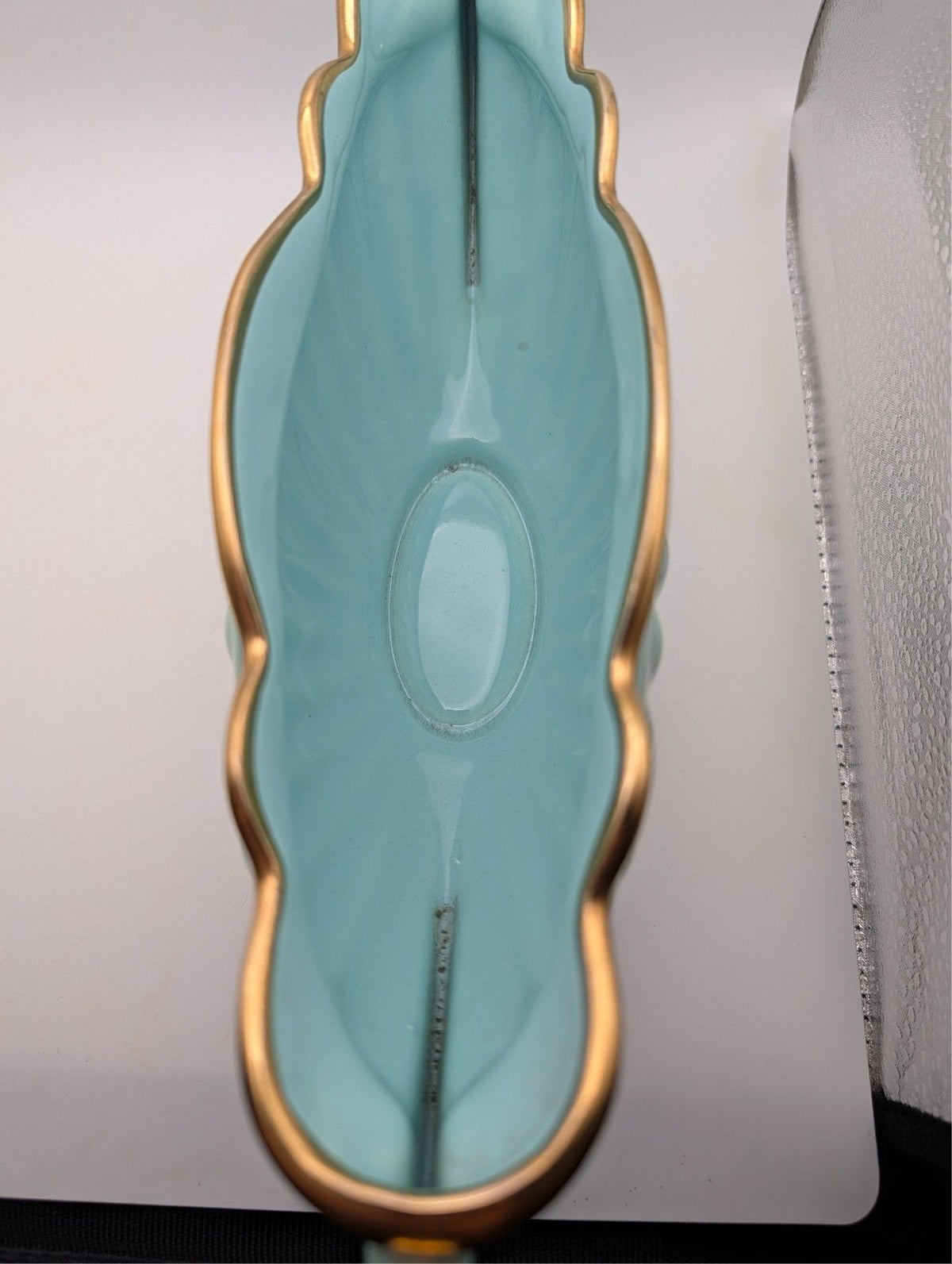 Blue-green oval bowl with gold rim and oval base cutout details