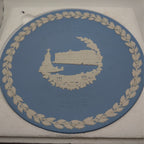 Blue Jasperware Christmas plate with white palace scene and gold wreath border