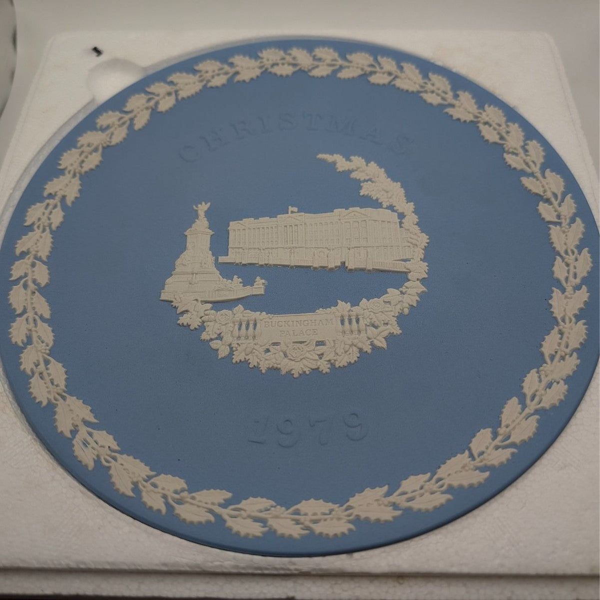 Blue Jasperware Christmas plate with white palace scene and gold wreath border