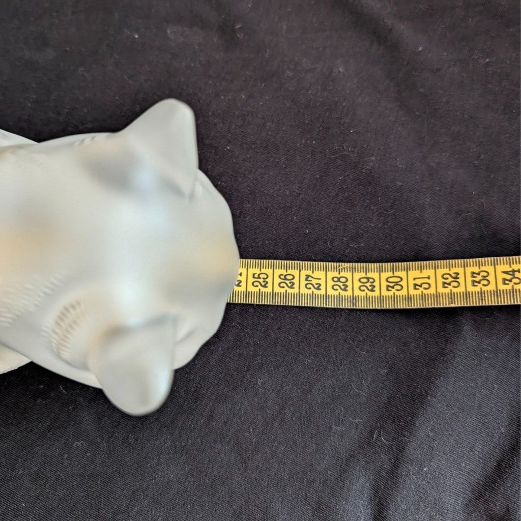 Frosted crystal cat sculpture next to measuring tape for size reference