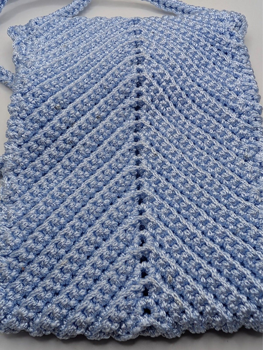 Light blue crochet phone bag with textured chevron stitch and crossbody strap