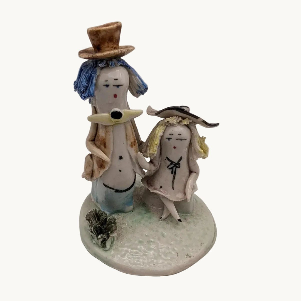 Seated and standing pottery couple figurine with blue-hatted figures and base