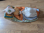 Reclining porcelain sultan figurine with white patterned pants, ornate vest, and turquoise cushion