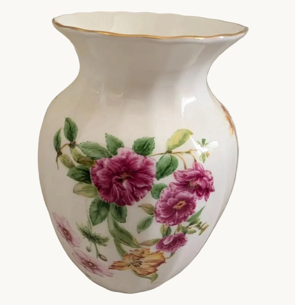 White bone china vase with purple pink flowers, green leaves, and gold rim
