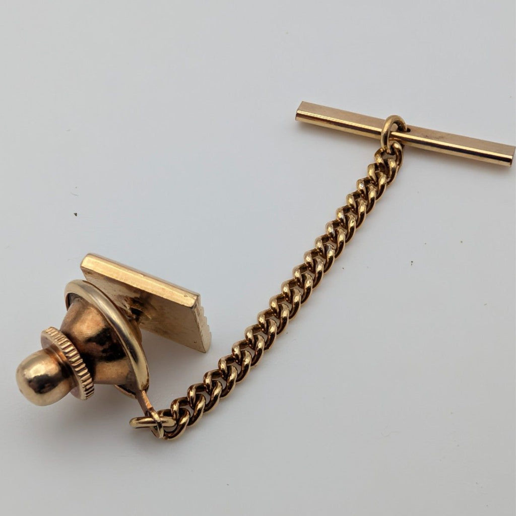 Gold-tone tie tack pin with bar post, retaining chain, and t-bar locking piece