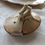 Cream porcelain teapot lid finial detail with gold-toned accents and opening