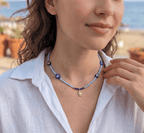 Beaded light blue choker with blue flower charms and small gold turtle pendant