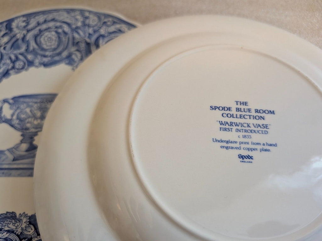 White porcelain plate bottom with Spode mark and 'Warwick Vase' text in blue.